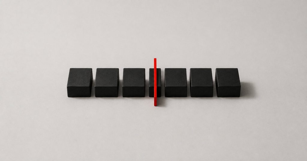 A row of black blocks on a pale surface with a single red vertical line cutting through the row.